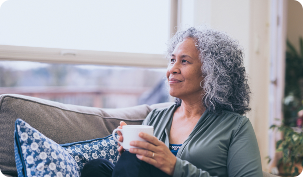 Older woman smiling at home with a cup of coffee